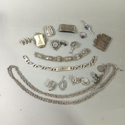 a lot of silver jewelry on a white table