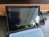 a laptop computer sitting on a desk with a person taking a picture