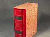 une image représentant un livre rouge posé sur une table