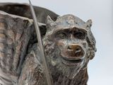 a statue of a monkey holding a sword and a bowl