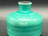 a green vase that is sitting on a table