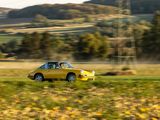 a yellow car that is driving down the road