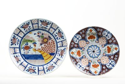 two plates with designs of birds and flowers on them on a white surface