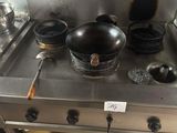 les casseroles et les poêles sont sur la cuisinière, dans la cuisine
