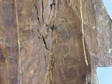 a wooden statue of a man with a cross on it ' s face