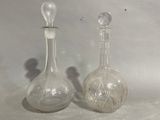 two glass bottles sitting next to each other on a table