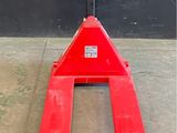 un chariot élévateur rouge posé sur un sol en béton