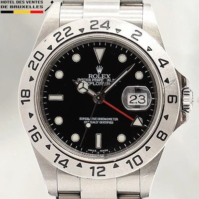 Montre Rolex avec cadran noir et aiguilles rouges, montée sur un bracelet en acier