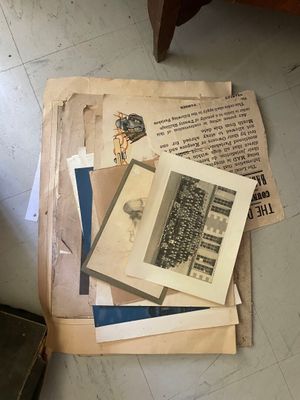 une pile de vieux papiers par terre, à côté d'une chaise