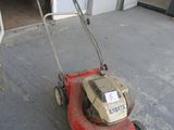 a red lawn mower that is sitting in the garage