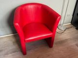 a red chair that is sitting in the corner of a room