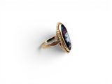 a gold ring with a blue stone in the center