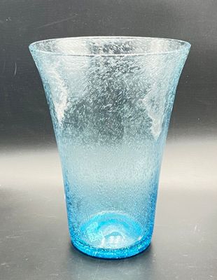 a blue glass vase sitting on a table