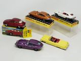 five toy cars on display in a display case