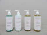 trois flacons de savon pour les mains et de lotion Clarins posés les uns à côté des autres
