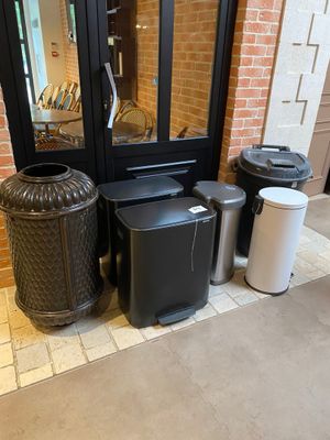 several trash cans are lined up in front of a door