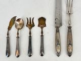 five forks, a knife, and a spoon on a table