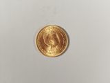a close up of a gold coin on a white surface