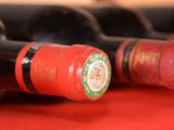 several bottles of red wine are lined up on a red table