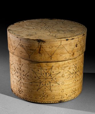 une vieille boîte en bois posée sur une table, devant un fond noir