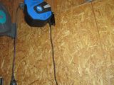 une photo d'un outil à cordon bleu et noir posé sur un parquet
