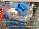 a metal shopping cart filled with assorted items in a kitchen
