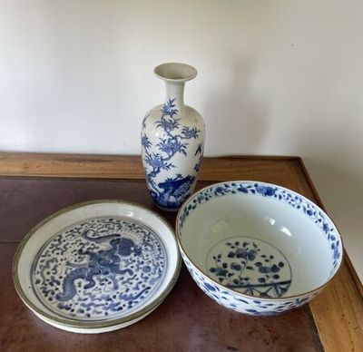 two blue and white bowls and a vase on a table