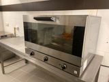 un four argenté posé sur un plan de travail dans une cuisine
