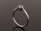 a close up view of a diamond ring on a reflective surface
