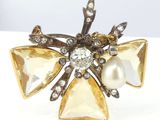 an image of a close up of a broochle with pearls and crystals