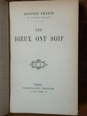 un livre ouvert posé sur une table à côté d'une pile de livres