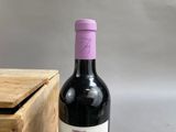a bottle of wine sitting next to a wooden box