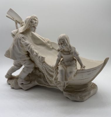 a figurine of a man and a woman in a boat