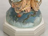 a figurine of a woman sitting on top of a rock