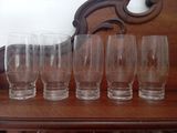 six glasses on a table with a mirror in the background