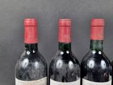 three bottles of red wine are lined up on a table