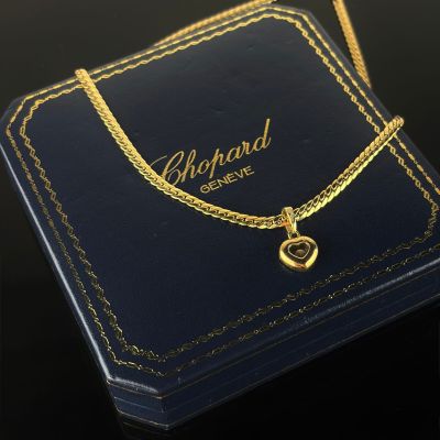 a close up of a gold necklace with a heart on it
