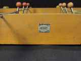 a wooden box with a bunch of wooden pegs in it