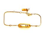Gros plan sur un bracelet en or orné d'une barre
