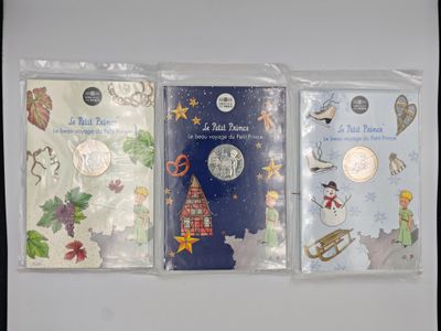 three christmas cards are lined up in plastic bags on a table