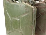 two green jerry cans sitting next to each other on a white surface