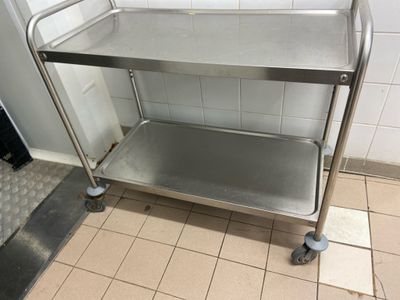 a metal cart that is on the floor in a bathroom