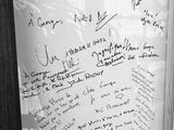 black and white photograph of a white board with writing on it