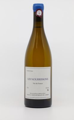 une bouteille de vin blanc posée sur une table blanche