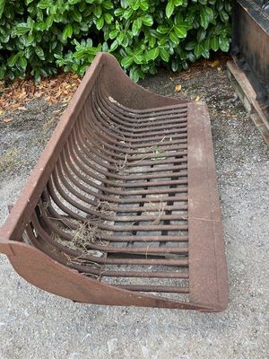 a rusted metal bench sitting on the sidewalk