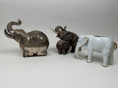 three figurines of elephants standing next to each other