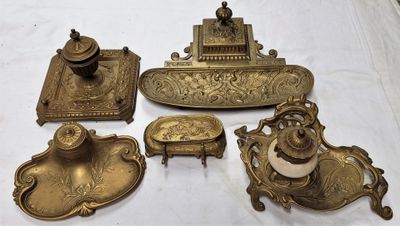 plusieurs objets anciens en laiton posés sur une nappe blanche