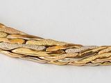 a close up of a gold necklace on a white surface