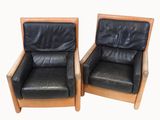 pair of black leather lounge chairs with wooden frame and arms