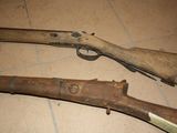 two old guns that are on the floor next to each other